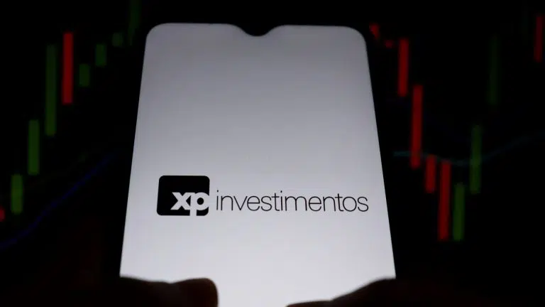 XP Investimentos em aplicativo, com gráficos ao fundo