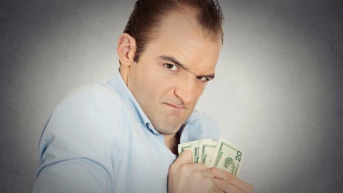 homem olhando engraçado segurando notas de dólar com medo de perder dinheiro