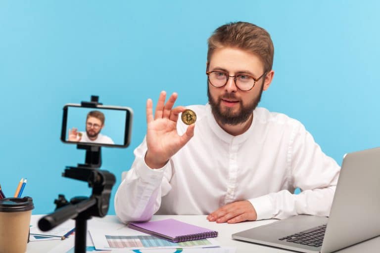 Influenciador digital gravando vídeo sobre criptomoedas.