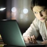 Mulher desconfiada ao ler e-mail