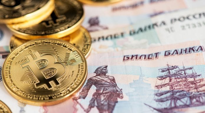 Moedas de Bitcoin e notas de rublos.