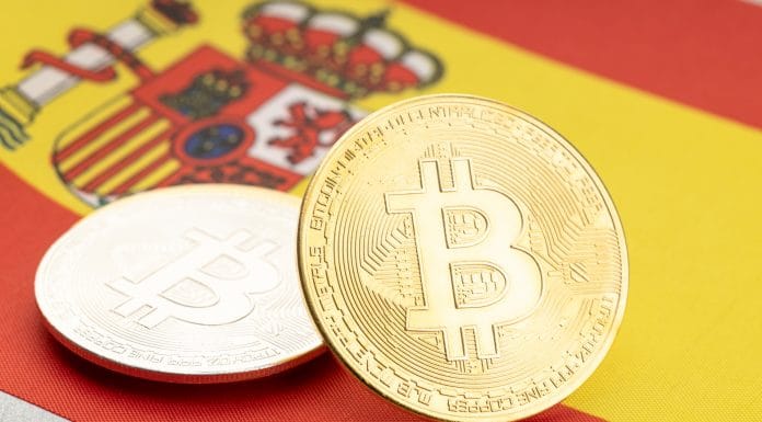 Bandeira da Espanha ao fundo e Bitcoin