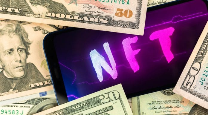 Celular com palavra NFT próximo de notas de dinheiro
