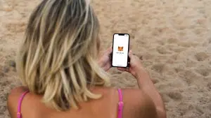 Garota na praia usando sua carteira MetaMask