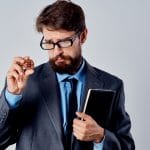 Homem curioso com óculos examina criptomoeda Bitcoin
