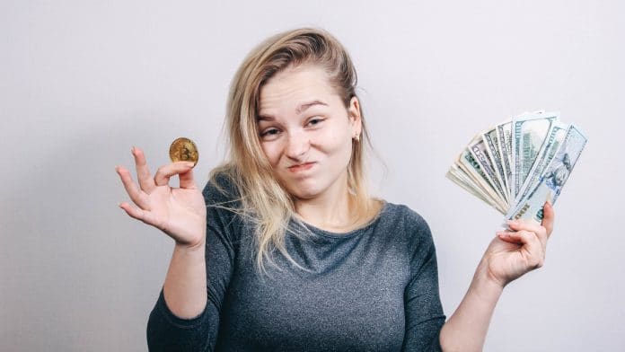 Mulher olhando com ceticismo para bitcoin