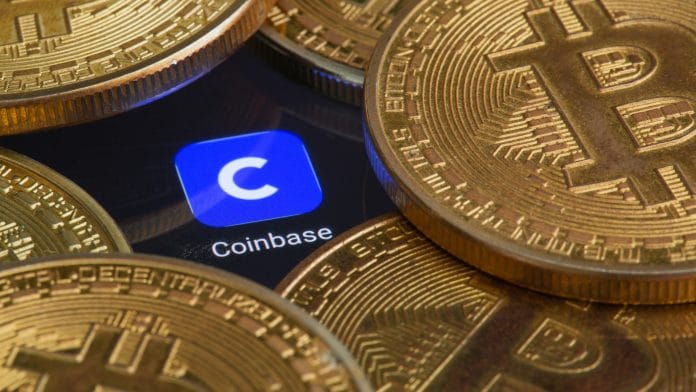 Símbolo com presença da Coinbase em meio a moedas de Bitcoin