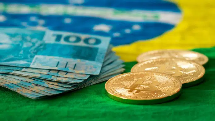 Bandeira do Brasil com notas de real e moedas de Bitcoin e criptomoedas