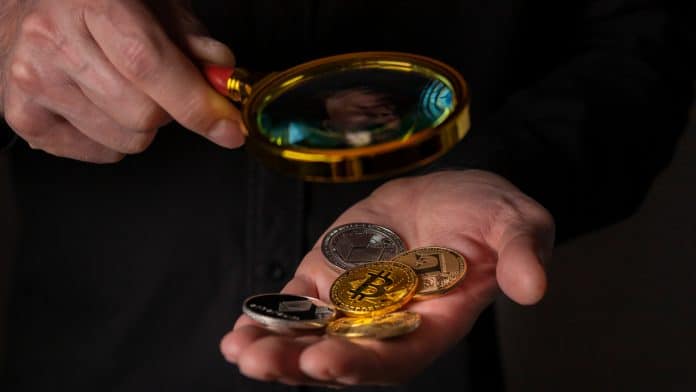 Lupa com criptomoedas, destaque para o Bitcoin.