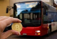 Moeda física de Bitcoin e ônibus.