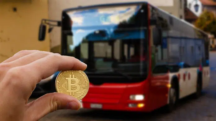 Moeda física de Bitcoin e ônibus.