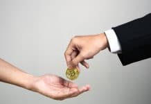 Empresário dando bitcoin para outra pessoa.