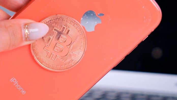 iPhone da Apple e moeda de Bitcoin.