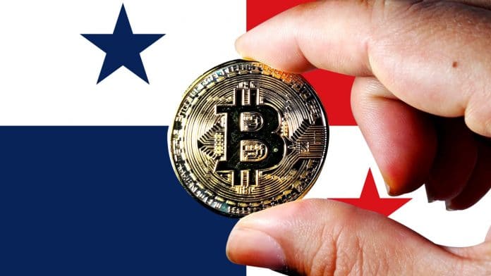 Bandeira do Panamá ao fundo com mão segurando Bitcoin na frente