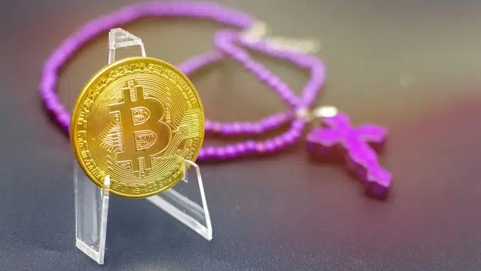 Bitcoin com colar de cruz roxa em fundo preto
