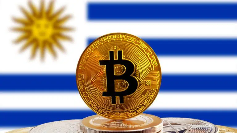 Bitcoin em cima de criptomoedas e bandeira do Uruguai ao fundo