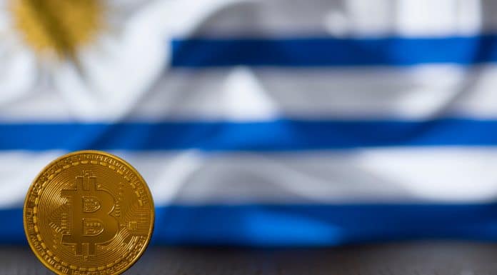 Bitcoin em frente a bandeira do Uruguai ao fundo
