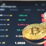 Imagem de Bitcoin, Binance Chain e Dogecoin próximo de aplicativo de negociações