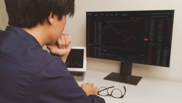 Jovem trader de Bitcoin e criptomoedas no computador