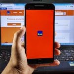 Mão segurando celular com aplicativo do Itaú