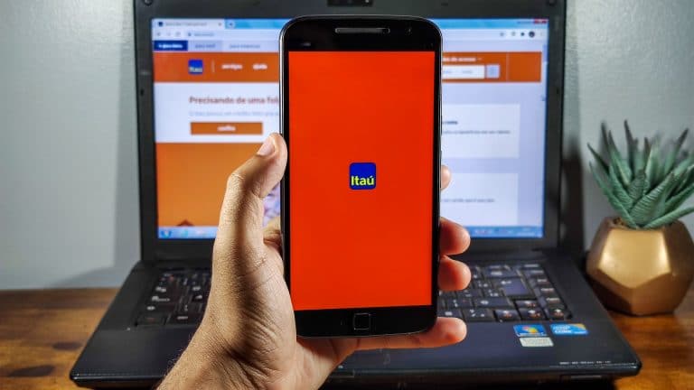 Mão segurando celular com aplicativo do Itaú