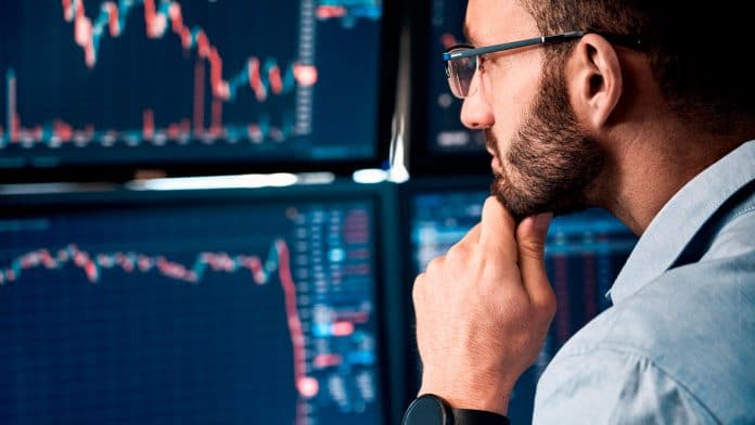 Investidor de Bitcoin pensativo enquanto encara site de exchange.