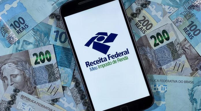 Aplicativo de imposto de renda da Receita Federal cercado de notas de Real