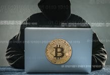 Hacker com computador com imagem do bitcoin