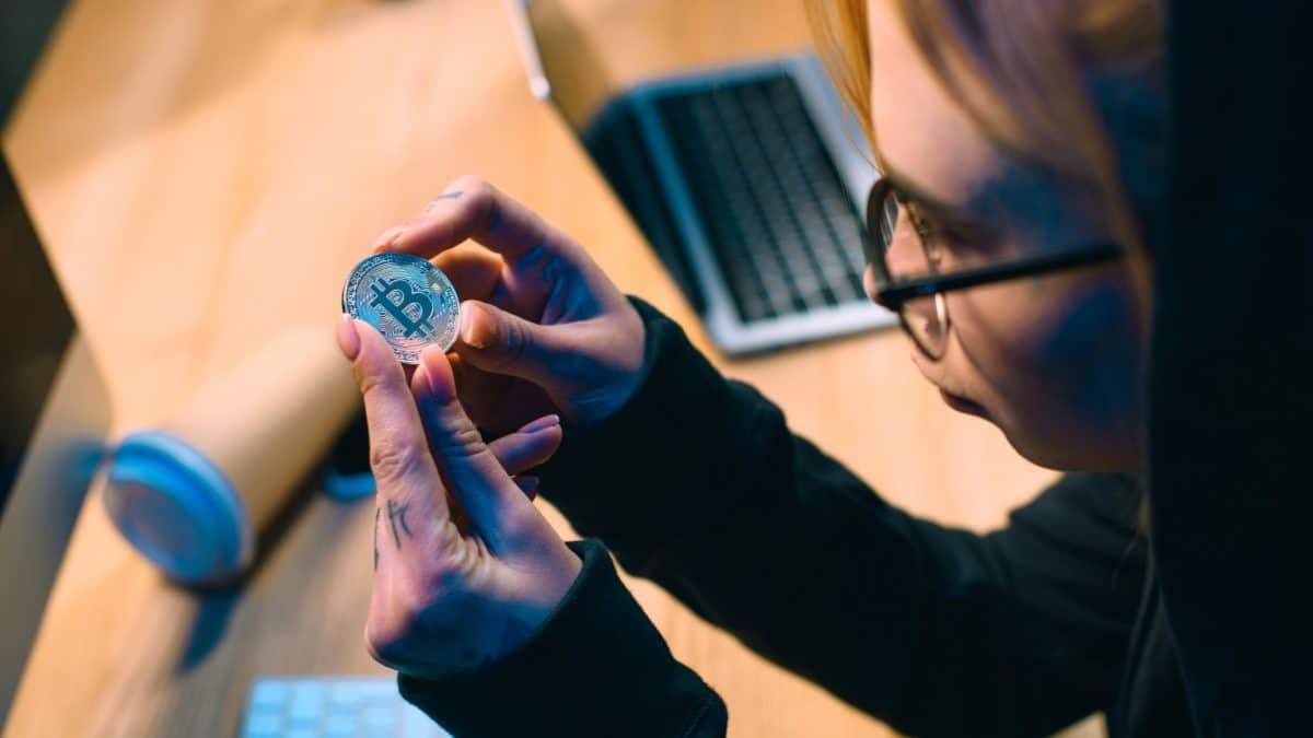 Jovem mulher segurando bitcoin