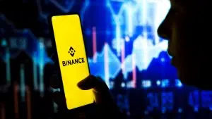 Mulher segura um smartphone com o logotipo da Binance (BNB) exibido na tela