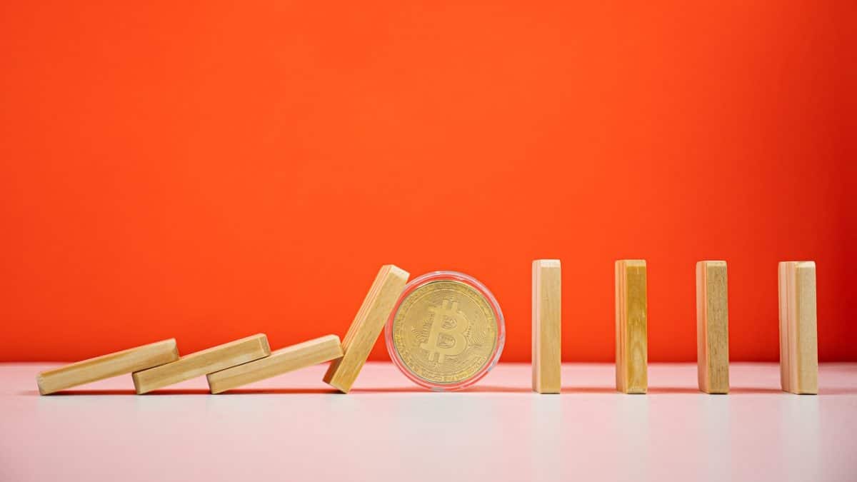 O efeito dominó parado por bitcoin forte em fundo laranja