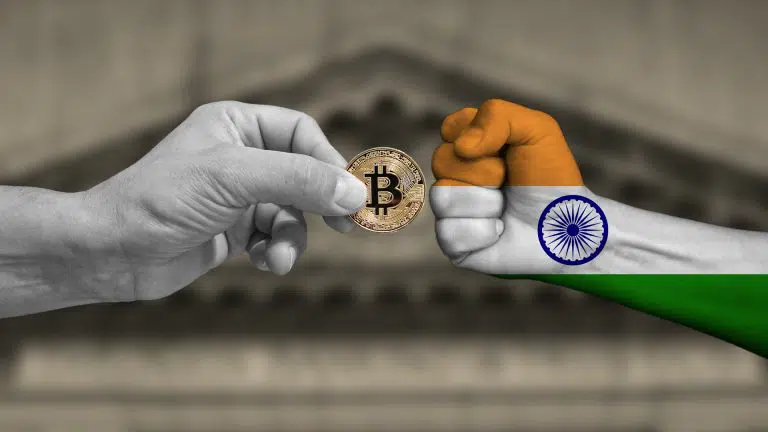 Punho cerrado com bandeira da Índia ao lado de mão com Bitcoin