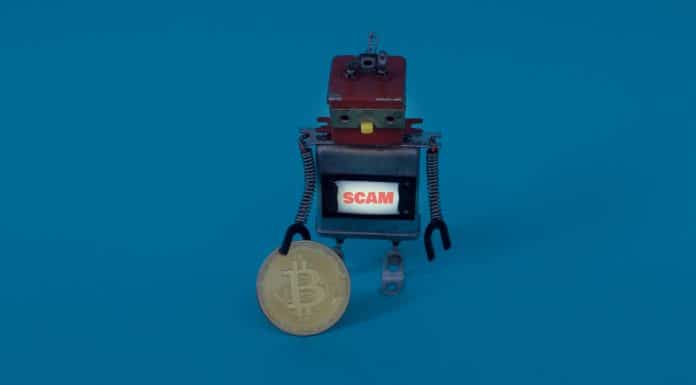Robô próximo de bitcoin com placa de scam