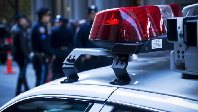 Viatura policial com agentes ao fundo