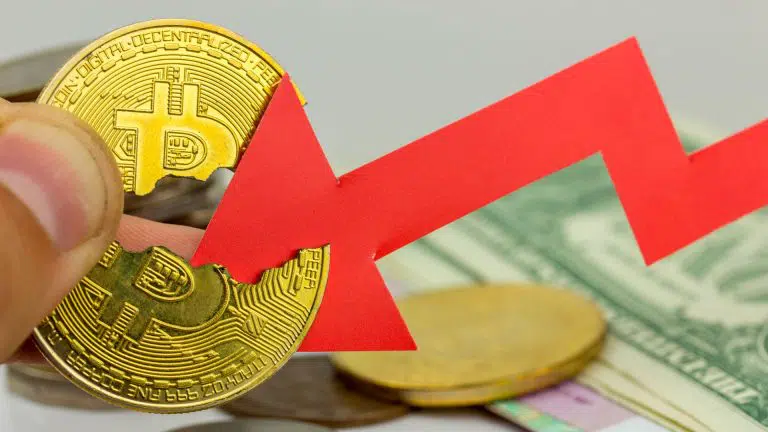 Bitcoin partido ao meio por símbolo de queda.