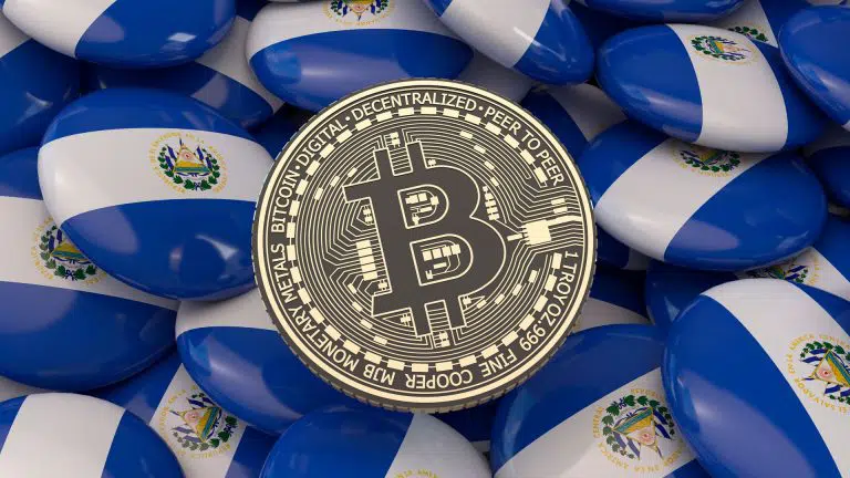 Botões com a bandeira de El Salvador e moeda física de Bitcoin ao centro.