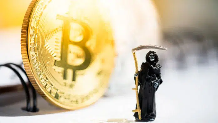 Ceifador, em frente à moeda de Bitcoin.