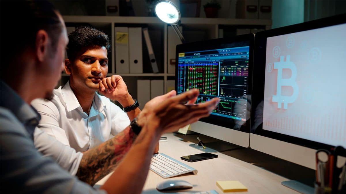 Duas pessoas conversando sobre Bitcoin, uma entusiasmada e outra cética.