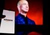 Celular com logo da Amazon na frente de foto de Jeff Bezos, fundador da empresa.