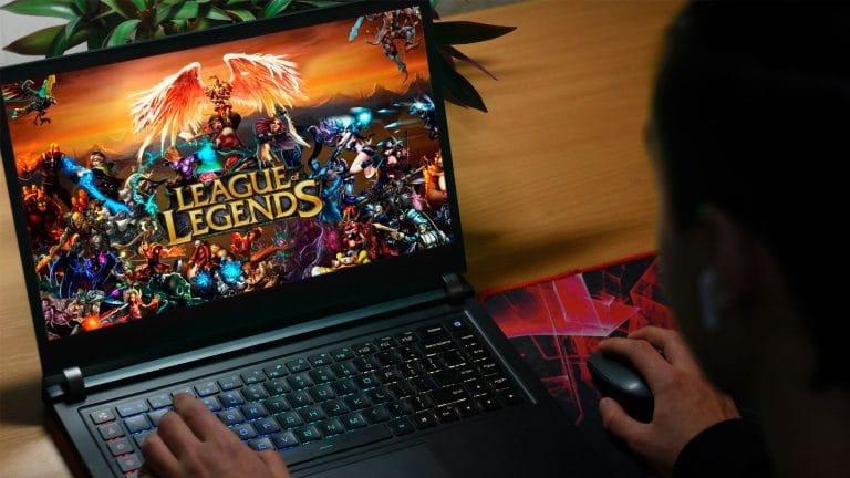 Jovem jogando League of Legends em notebook.
