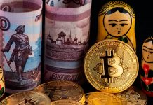Moedas físicas de Bitcoin ao lado de rublos da Rússia e matrioskas.