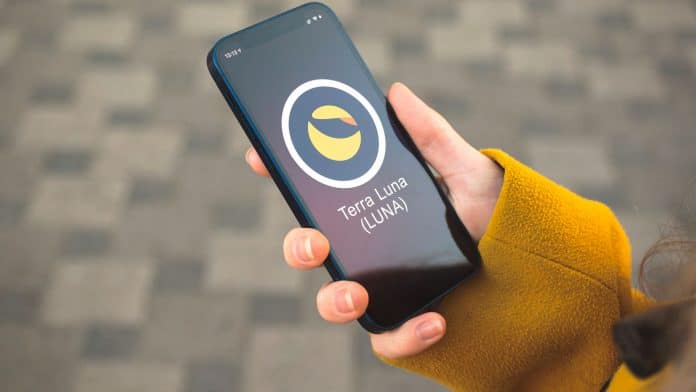 Mão segurando celular com tela da criptomoeda Terra (LUNA), responsável pela TerraUSD (UST).