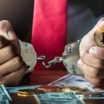 Homem preso e segurando bitcoin