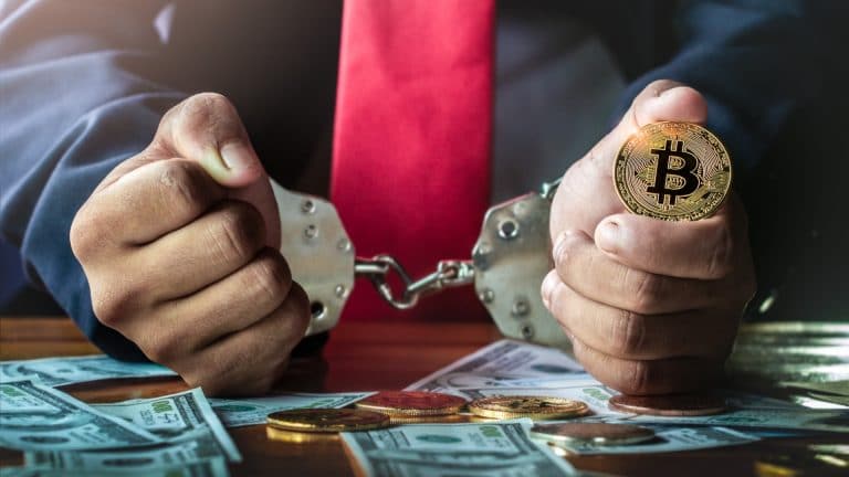Homem preso e segurando bitcoin
