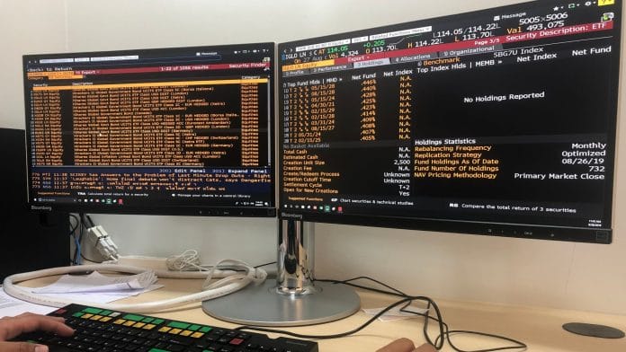 Investidor do mercado de ações usando a ferramenta Terminal Bloomberg para olhar o mercado