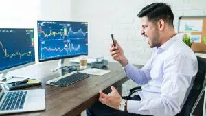Jovem comerciante de criptomoedas gritando enquanto olha para o celular