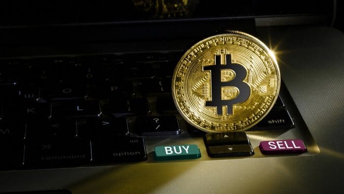 Moeda de bitcoin próxima de botão de compra ou venda