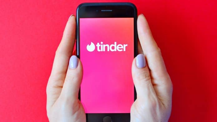 Mulher segurando celular com Tinder