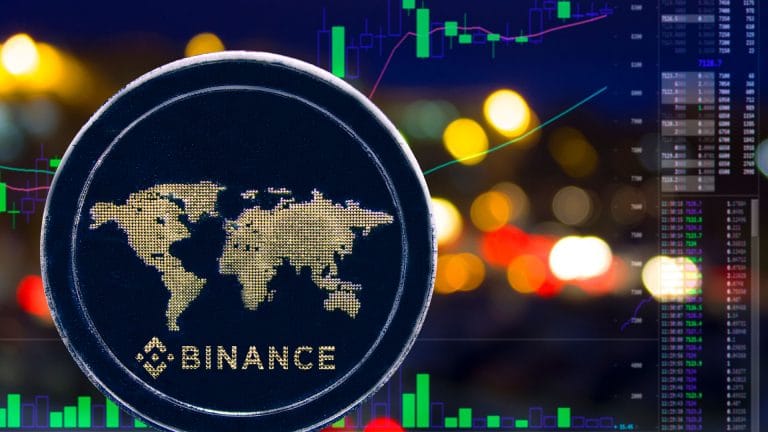 Logotipo da Binance em moeda, em frente à exchange.