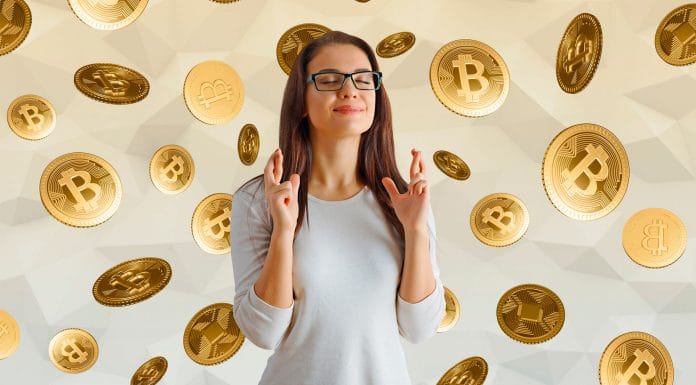 Mulher esperançosa com dedos cruzados cercada de moedas de Bitcoin.